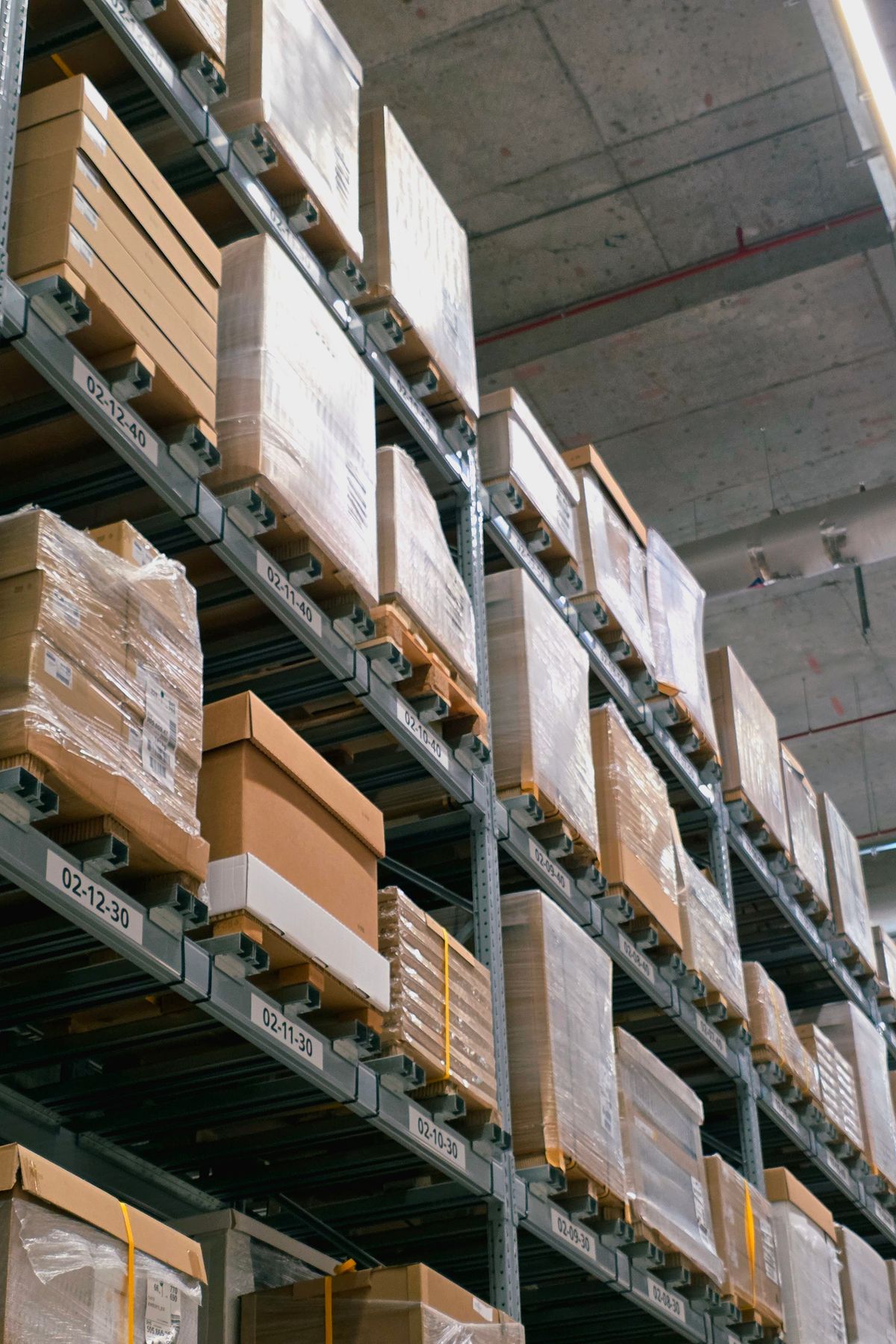 Warehouse racking with stacked pharmaceutical supply cartons for out-licensing partners
